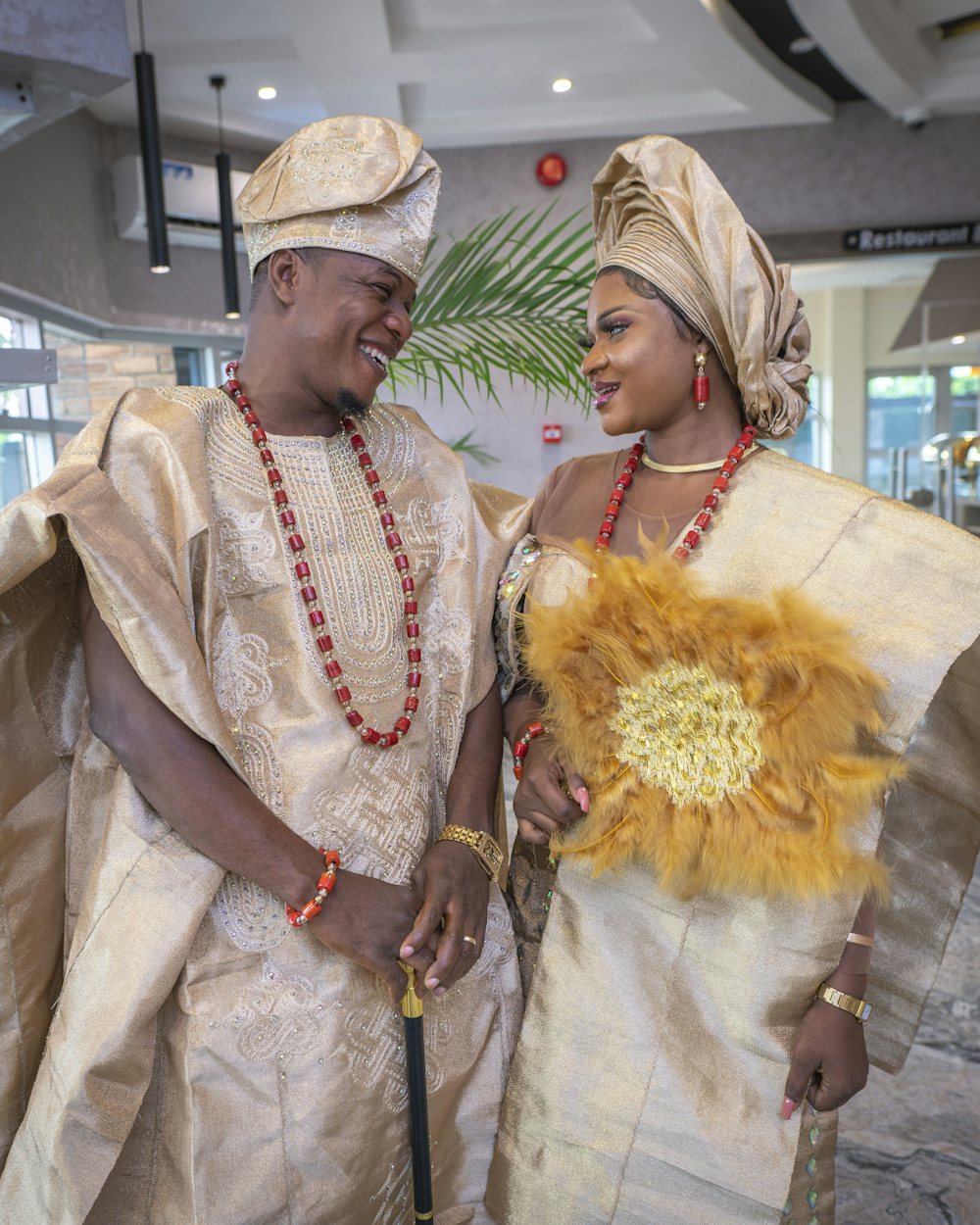 Couple ouest-africain en tenue traditionnelle dorée, souriant